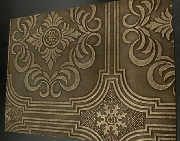 Flat panel with raised dark bronze floral scroll pattern