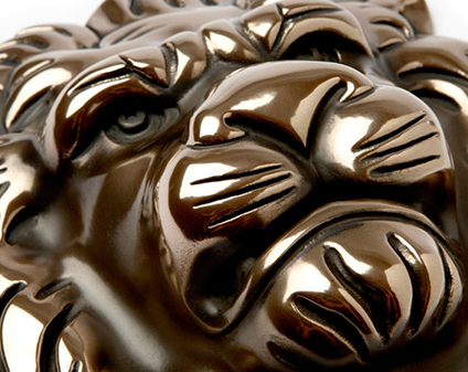 Close view of lion face relief in polished bronze